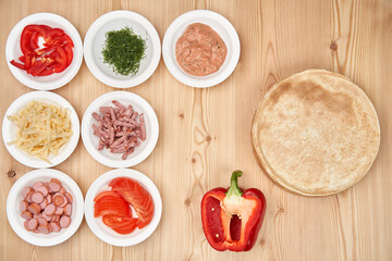 Slicing fresh food for pizza, with dough on a wooden background. Delicious homemade food.