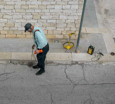technical with water leak detector on a road of on city. These detectors are an important tool to detect the sound of leaks in noisy cities.