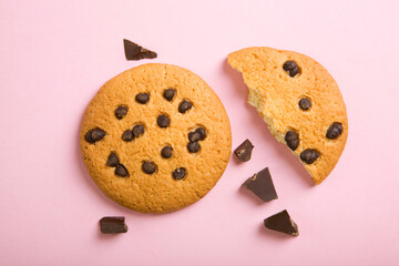 Delicious cookies with chocolate chips on a colored background