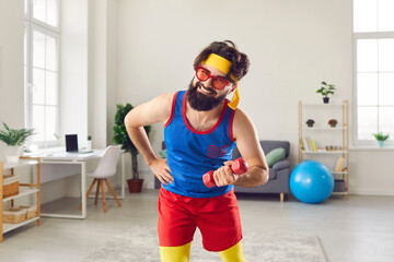 Funny and hardy man in colorful colored sportswear doing sports workout with dumbbells at home.
