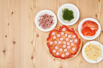 Making pizza surrounded by ingredients. Close-up with copy space.View from above.