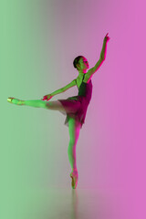 Feminine. Young and graceful ballet dancer isolated on gradient pink-green studio background in neon. Art, motion, action, flexibility, inspiration concept. Flexible ballerina, weightless jumps.