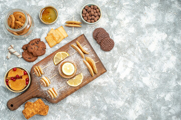 Above view of easy pancakes with lemons on cutting board and cookies honey on blue background