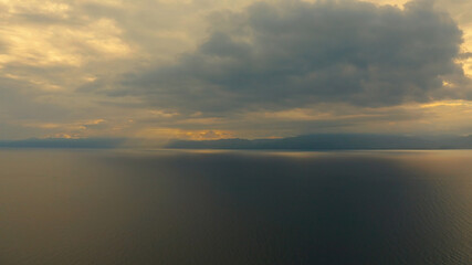 Obraz premium Sunset above the sea surface with waves, top view. Reflected sun on a water surface. Sunset over ocean. Seascape, Summer and travel vacation concept