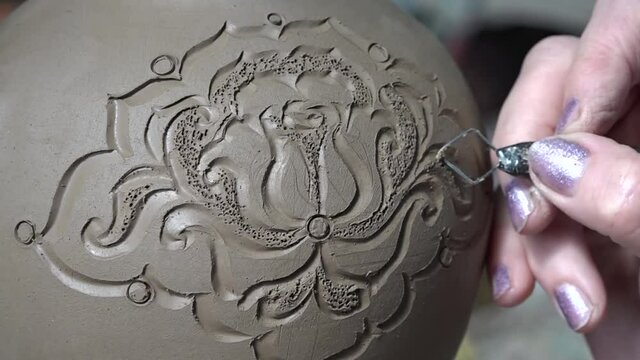 Painting a jug in the pottery production of tableware.