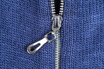 Macro shot of zipper on blue wool texture background with stitching. Horizontal background from a close-up of wool material © Aleksei