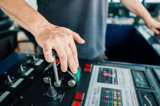 Captain of deck Officer on bridge of vessel or ship during navigaton watch at sea . He is maneuvering with cpp thrusters propulsion and bowthruster. Closeup view