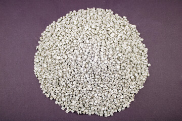 Raw material plastic granules white gray, close-up raw material brown background!