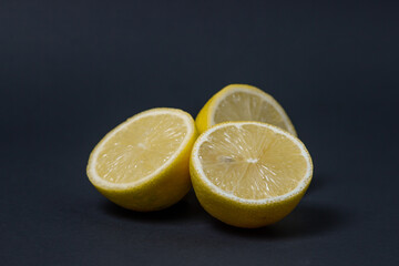 Lemons on a black background. Citrus fruit. Healthy food. Sliced lemon. Sour fruit
