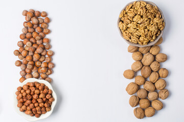 Heap of hazel nuta and walnuts on white