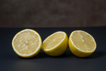 Lemons on a black background. Citrus fruit. Healthy food. Sliced lemon. Sour fruit