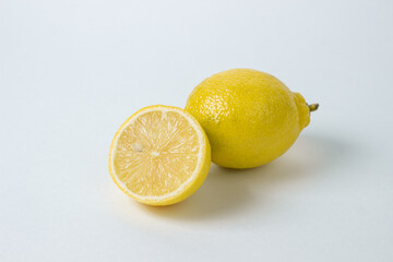 Lemons on a white background. Citrus fruit. Healthy food. Sliced lemon. Sour fruit