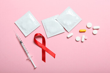 Condoms and red ribbon symbolizing AIDS. World AIDS Day - obrazy, fototapety, plakaty