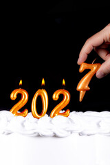 Golden candles write numbers flame Happy new year 2027 hand