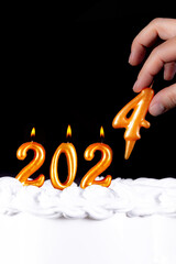 Golden candles write numbers flame Happy new year 2024 hand