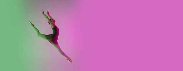 Flyer, copyspace. Young and graceful ballet dancer isolated on gradient pink-green studio background in neon. Art, motion, action, flexibility, inspiration concept. Flexible ballerina, weightless © master1305
