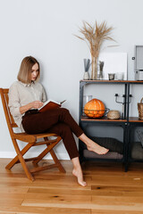 portrait of a young woman reading a book in a beautiful interior.