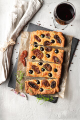 Baked focaccia with tomatoes, black olives and rosemary.