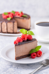 Chocolate cheesecake with fresh raspberries and mint leaves.