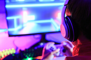 Gamer playing online game on PC in dark room. © Kannapat