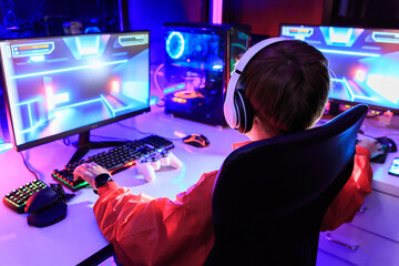 Gamer playing online game on PC in dark room. - obrazy, fototapety, plakaty