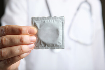 condoms in the hands of a doctor in a white coat