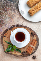 top view tasty cake slices with cup of tea on light desk sweet biscuit cake pie
