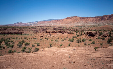 Amazing sandstone monoliths in a barren desert prairie on a blue partly cloudy summer day at Capitol Reef National Park in Torrey Utah