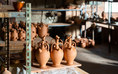 Clay jugs and utensils on racks in store. High quality photo