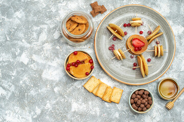 Above view of delicious pancakes with fruit and honey on blue background