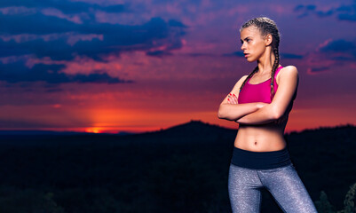 Determined Athletic Fitness Woman on Hills at Sunset, looking right, arms crossed, personal instructor