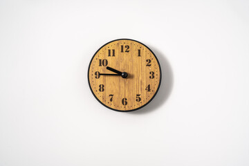 wood office wall clock with white dial on white background. wall clock on white background, top view.