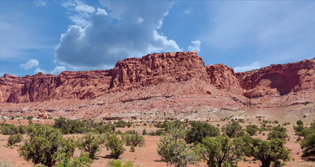 Amazing sandstone monoliths in a barren desert prairie on a blue partly cloudy summer day at Capitol Reef National Park in Torrey Utah