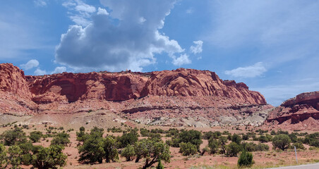 Amazing sandstone monoliths in a barren desert prairie on a blue partly cloudy summer day at Capitol Reef National Park in Torrey Utah