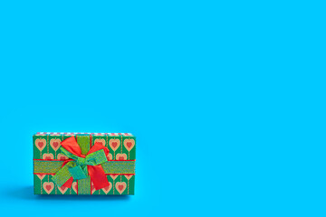 holiday gift box for christmas and new year on blue background, minimal design concept of holiday decoration
