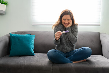 Obraz premium Young woman looking excited for the results of her pregnancy test