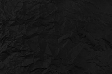 Black crumpled paper texture background.