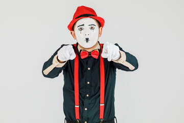 Clown with red suspenders and red hat on white background