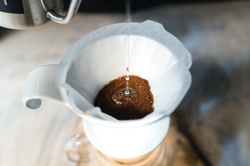 Drip coffee, barista pouring water on coffee ground with filter