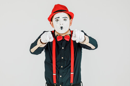 Clown with red suspenders and red hat on white background