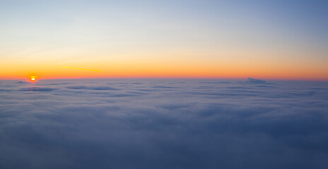 Fototapeta na wymiar Amazing sunrise above clouds from the top of the mountain