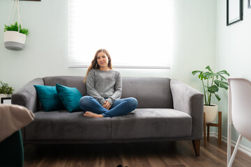 Obraz premium Portrait of a pretty woman resting on her sofa