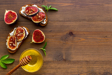 Fototapeta na wymiar Figs with cream cheese and honey sandwich. Top view