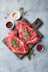 Two Fresh Raw meat Prime Black Angus Beef Steaks, Rib Eye, Denver, on wooden cutting board.