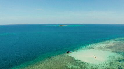 Obraz premium Sandy beach with tourists on a coral atoll in turquoise water, from above. Summer and travel vacation concept. Balabac, Palawan, Philippines.