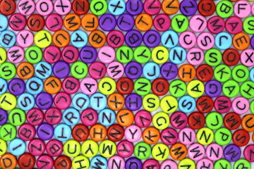 Textured background image, top view filled with spherical beads, containing characters of various colors