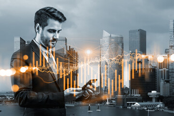 Fototapeta premium Handsome Caucasian trader checking quotes to forecast the capital market behavior. Concept of trading strategy. Forex chart. Singapore. Double exposure.