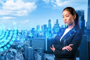 Fototapeta na wymiar Attractive young Asian businesswoman in suit thinking about career opportunities at research and development department at international company. Hologram icons over Singapore background.