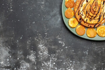 Half shot of pancake decoration on a green plate for breakfast on gray background horizontal view