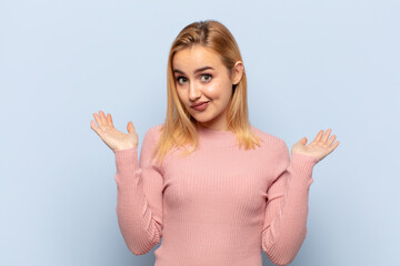 young blonde woman feeling puzzled and confused, doubting, weighting or choosing different options...